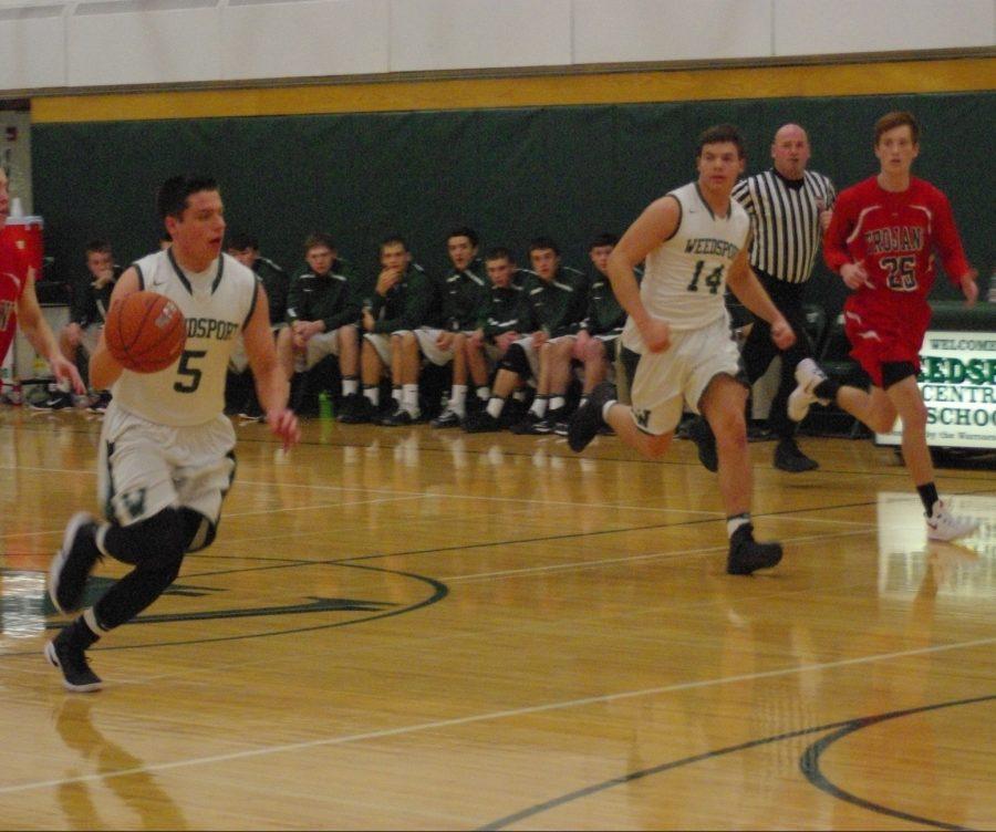 Jake OConnor takes the ball up court as Jeff DeJohn runs along side him.