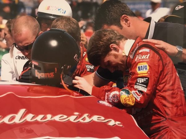 Quinn talks to Dale Earnhardt Jr. before a NASCAR race. He worked as a trainer for NASCAR during this time.